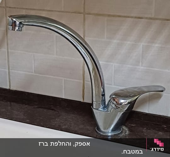 ברז מטבח כסוף מותקן על שיש כהה